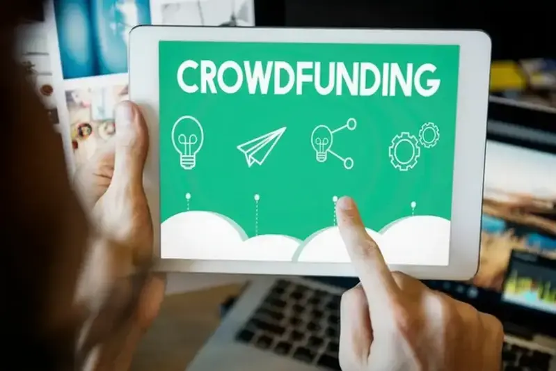 Una persona revisando una plataforma de crowdfunding en una tablet, con notificaciones de proyectos interesantes.
